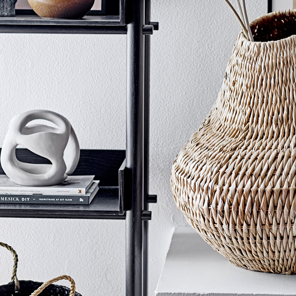 Polyresin sculpture with rattan basket on a shelf