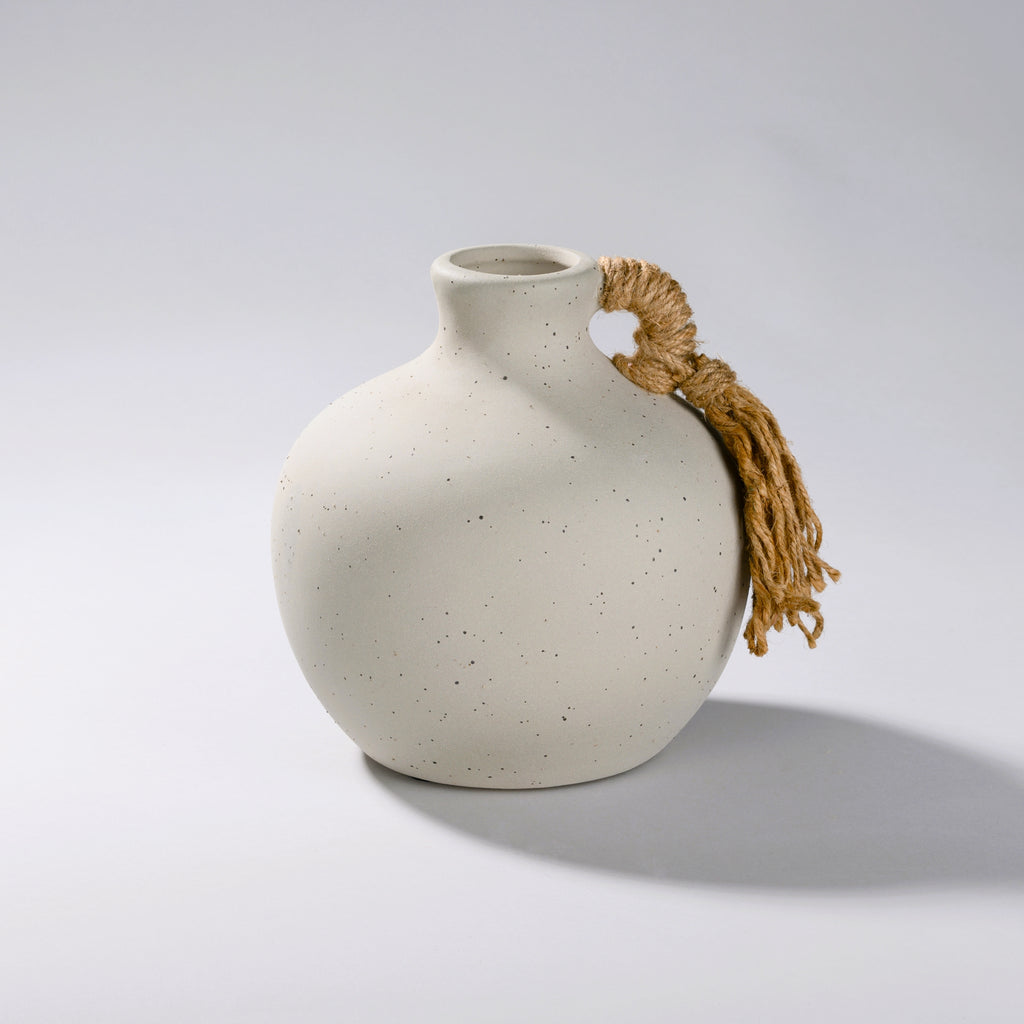grey ceramic vase with a black speckled glaze and woven rope handle with a short round body